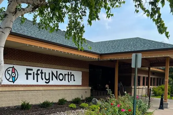 Exterior of the FiftyNorth community center building with a large banner and landscaped entrance