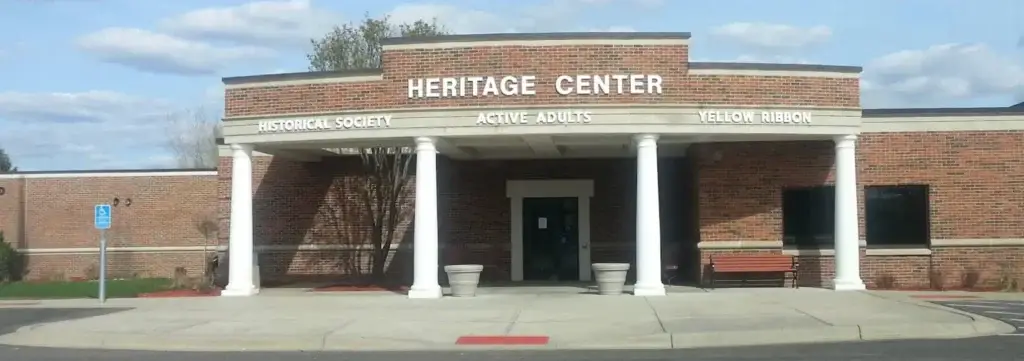 Front entrance of Heritage Center in Lakeville, MN, with brick exterior, white columns, and signage for Historical Society and Active Adults.