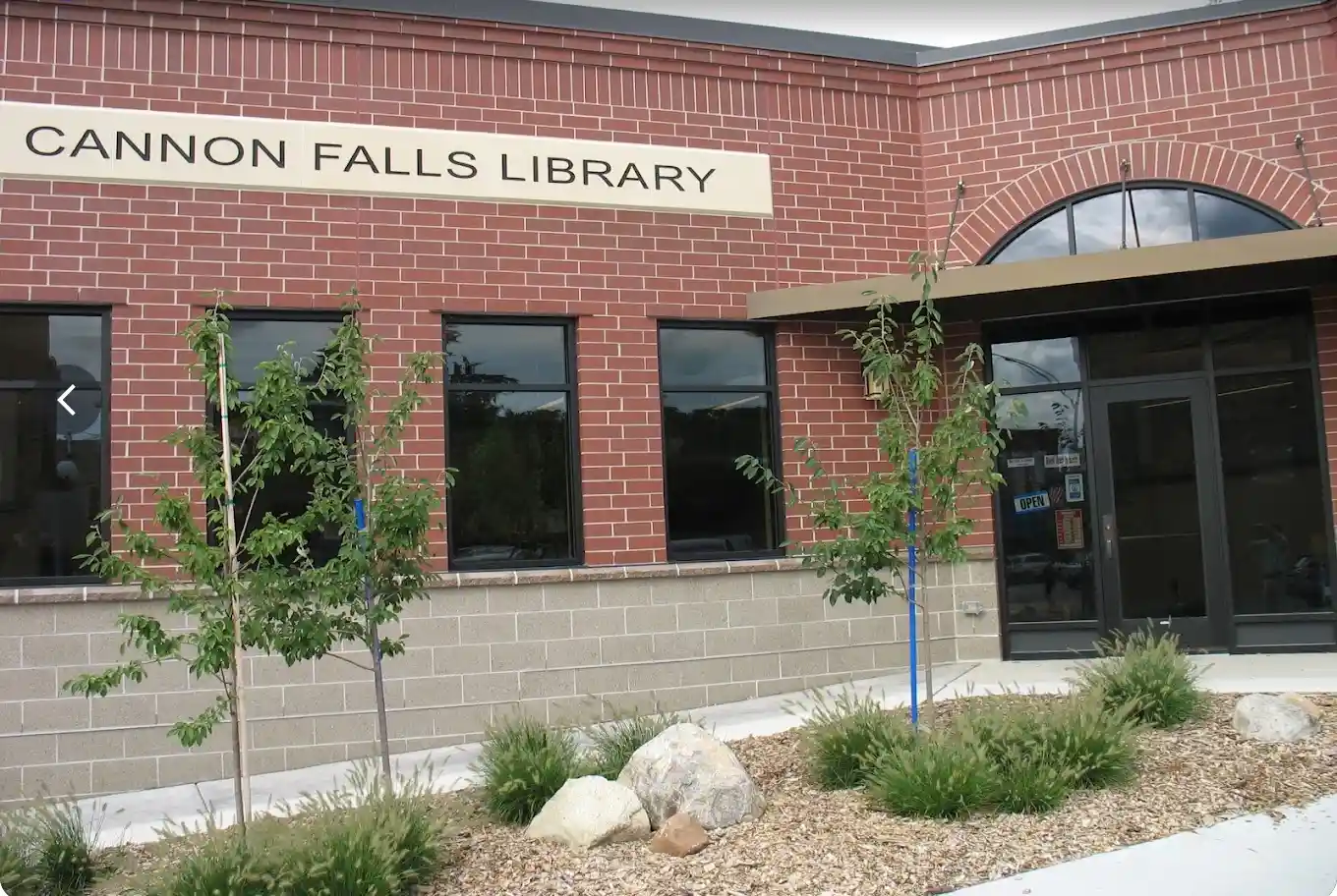Exterior of Cannon Falls Library in Cannon Falls, Minnesota, with its brick facade, entrance and landscaping.